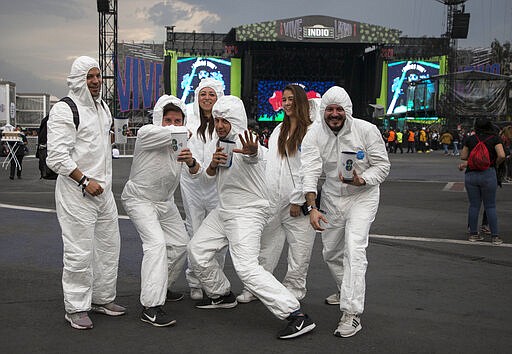 Music fans dressed in bio suits strike a pose during the Vive Latino music festival in Mexico City, Saturday, March 14, 2020. The two-day rock festival is one of the most important and longest running of Mexico. (AP Photo/Christian Palma)