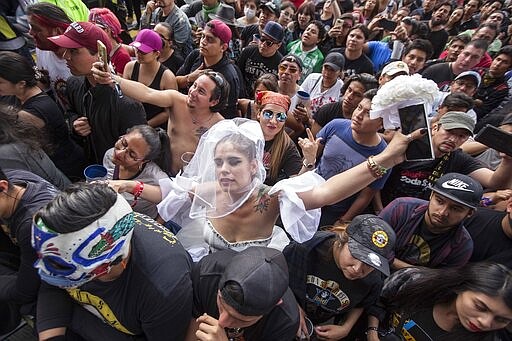 A woman dressed as a bride dances at the Vive Latino festival in Mexico City, Saturday, March 14, 2020. On Friday afternoon organizers confirmed that the 21st edition of the festival will go on as planned.  (AP Photo/Christian Palma)