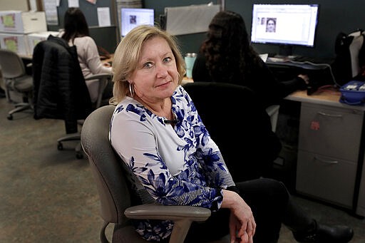 In this Thursday, Jan. 16, 2020 photo Jo Goode, city hall reporter for The Herald News of Fall River, Mass., sits for a photo in the paper's newsroom, in Fall River. Goode's paper has already laid off most of its reporting staff and recently announced plans to sell its historic downtown office to trim costs. (AP Photo/Steven Senne)