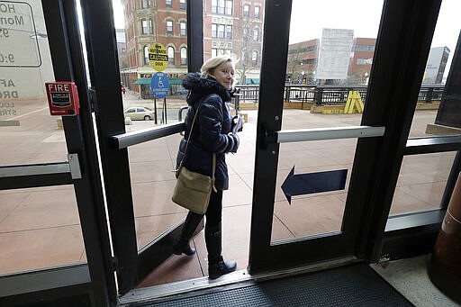 In this Thursday, Jan. 16, 2020 photo Jo Goode, city hall reporter for The Herald News, exits Fall River City Hall, in Fall River, Mass. Goode's paper has already laid off most of its reporting staff and recently announced plans to sell its historic downtown office to trim costs. (AP Photo/Steven Senne)