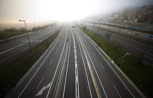 The highway leading to Barcelona is seen empty of cars on Sunday, March 15, 2020. Spain's government announced Saturday that it is placing tight restrictions on movements and closing restaurants and other establishments in the nation of 46 million people as part of a two-week state of emergency to fight the sharp rise in coronavirus infections. For most people, the new coronavirus causes only mild or moderate symptoms. For some, it can cause more severe illness, especially in older adults and people with existing health problems. (AP Photo/Emilio Morenatti)