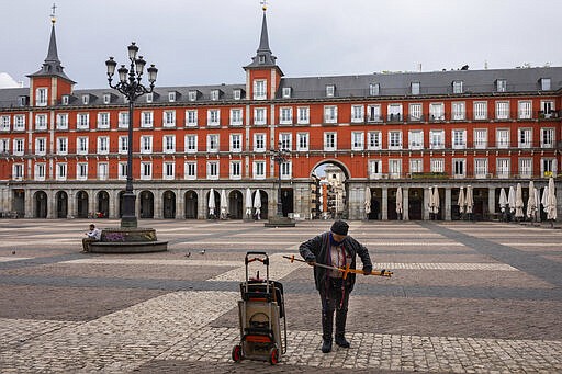 Spanish cartoonist Maria del Rosario &quot;Chary&quot; closes his stall after been told by local police to leave Mayor square in downtown Madrid, Spain, Sunday, March 15, 2020. Spain awoke to its first day of a nationwide quarantine on Sunday after the government declared a two-week state of emergency. The government imposed the special measures including the confinement of people to their homes unless shopping for food and medicine, going to and from work, and to meet other basic needs. The vast majority of people recover from the new coronavirus. According to the World Health Organization, most people recover in about two to six weeks, depending on the severity of the illness. (AP Photo/Bernat Armangue)