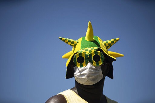 A man wears a mask during a rally supporting Brazil's President Jair Bolsonaro on Copacabana beach, Rio de Janeiro, Brazil, Sunday, March 15, 2020. Thousands took to the streets on Sunday to demonstrate in favor of  Bolsonaro, challenging in some states the ban on agglomerations due to coronavirus and ignoring his suggestion to postpone the acts. (AP Photo/Silvia Izquierdo)