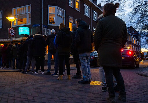 People queue to buy marijuana at  the coffeeshop Bulwackie in Amsterdam, Netherlands, Sunday, March 15, 2020, after a TV address by health minister Bruno Bruins who ordered all Dutch schools, cafes, restaurants, coffeeshops and sport clubs to be closed on Sunday as the government sought to prevent the further spread of coronavirus in the Netherlands. For most people, the new coronavirus causes only mild or moderate symptoms, such as fever and cough. For some, especially older adults and people with existing health problems, it can cause more severe illness, including pneumonia. (AP Photo/Peter Dejong)