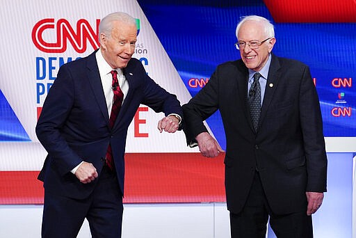 Former Vice President Joe Biden, left, and Sen. Bernie Sanders, I-Vt., right, greet each other before they participate in a Democratic presidential primary debate at CNN Studios in Washington, Sunday, March 15, 2020. (AP Photo/Evan Vucci)