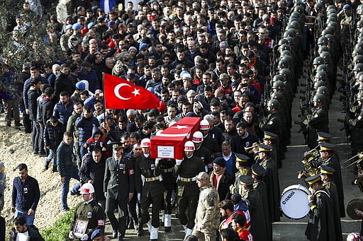 FILE - In this Feb. 29, 2020 file photo, An honour guard carries the coffin of Muhammed Ali Ozer, one of the 36 Turkish soldiers killed on Thursday in a Syrian army attack in the Idlib area of Syria, in Hatay, Turkey. In a world gripped by a pandemic, global unrest and a fast-moving news cycle, it can be difficult to remember that the war in Syria is still happening. (AP Photo/ File)