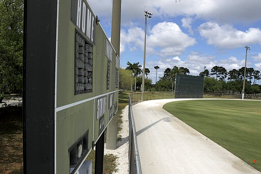 An empty practice field is seen at the Miami Marlins spring training baseball facility, Monday, March 16, 2020, in Jupiter, Fla. On Sunday night, the Centers for Disease Control and Prevention recommended gatherings of 50 people or more be canceled or postponed across the country for the next eight weeks. Major League Baseball planned to update teams Monday on its health policy.(AP Photo/Julio Cortez)