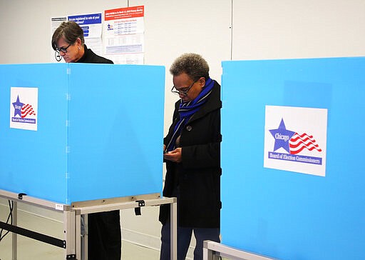 In this Saturday, March 14, 2020 photo, Chicago Mayor Lori Lightfoot casts her ballot during early voting in Chicago. The Illinois state primary elections are scheduled for Tuesday, March 17.  (AP Photo/ Noreen Nasir)