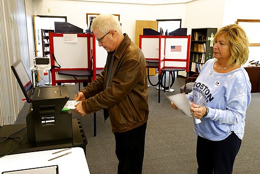 Greg Froehlinch and his wife Deb of Steubenville, Pa., take advantage of early voting, Sunday, March 15, 2020, in Steubenville, Ohio. Elections officials in the four states, Arizona, Florida, Illinois and Ohio, holding presidential primaries next week say they have no plans to postpone voting amid widespread disruptions caused by the coronavirus outbreak. Instead, they are taking extraordinary steps to ensure that voters can cast ballots and polling places are clean. (AP Photo/Gene J. Puskar)