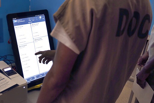 In this Saturday, March 14, 2020 photo, a Cook County jail inmate participates in early voting for the March 17, Illinois primary at the jail in Chicago. (AP Photo/Charles Rex Arbogast)