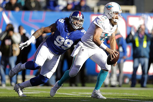 FILE - In this Dec. 15, 2019, file photo, Miami Dolphins quarterback Ryan Fitzpatrick (14) looks to pass under pressure from New York Giants defensive end Leonard Williams (99) in the second half of an NFL football game, in East Rutherford, N.J. The Giants have placed a non-exclusive franchise tag on defensive tackle Leonard Williams. The Giants announced the move Monday, March 16, 2020.(AP Photo/Adam Hunger, Fle)