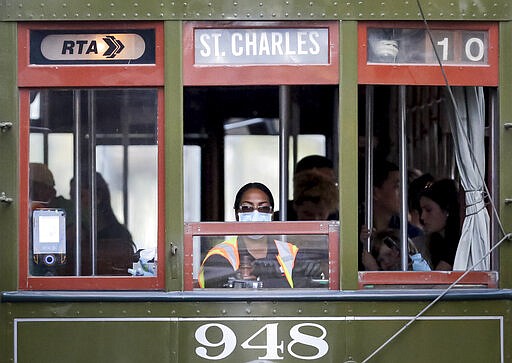 A streetcar conductor wears a mask on St. Charles Avenue in New Orleans on Saturday, March 14, 2020, amid an outbreak of the COVID-19 coronavirus. (Scott Threlkeld/The Advocate via AP)