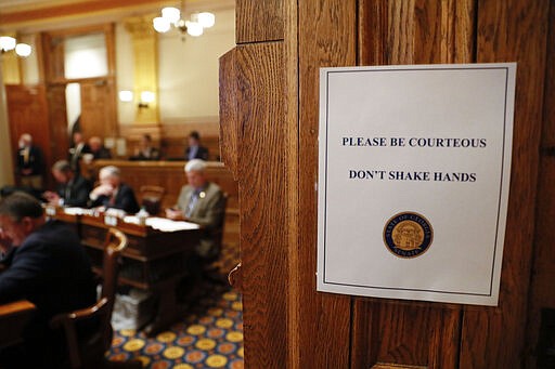 Signs in the senate chamber say &quot;Don't shake hands&quot; as Georgia lawmakers met during a special session on Monday, March 16, 2020 in Atlanta. Georgia's lawmakers are granting Gov. Brian Kemp broad powers to combat the spread of the new coronavirus in the state.   They set April 13, the Monday after Easter, as the end date for Kemp's powers.     The vast majority of people recover from the new coronavirus. According to the World  Health Organization, most people recover in about two to six weeks, depending on the severity of the illness.  (Bob Andres/Atlanta Journal-Constitution via AP)