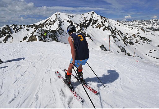 FILE - In this June 14, 2019, file photo, a skier takes a run as skiers and snowboarders continue to enjoy the late-season conditions at Snowbird Resort, near Salt Lake City. Ski resorts are grappling with how to help prevent the spread of the coronavirus while most planned to stay open as they try to salvage the final month-plus of the ski season. Snowbird resort in Utah said it will close it's aerial tram but stay open, explaining in an online post, &quot;it is our foundational belief that it is beneficial for the soul to live and enjoy the adventure lifestyle, and this is particularly the case in times like this, when anxiety and stress are high. (AP Photo/Rick Bowmer, File)