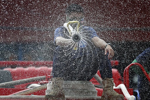 Firemen spray disinfectants outside a public market in Manila, Philippines, March 11, 2020. (AP Photo/Aaron Favila)