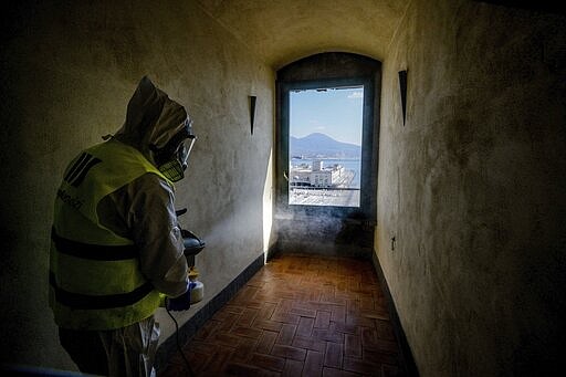 A worker sprays disinfectant as sanitization operations against Coronavirus are carried out in the museum hosted by the Maschio Angioino medieval castle, in Naples, Italy, March 10, 2020. (Alessandro Pone/LaPresse via AP)