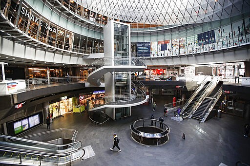 A pedestrian passes a nearly empty Fulton Center station as businesses are closed due to coronavirus concerns, Monday, March 16, 2020, in New York. New York leaders took a series of unprecedented steps Sunday to slow the spread of the coronavirus, including canceling schools and extinguishing most nightlife in New York City.  New York City entered a new phase in the coronavirus pandemic Monday with all the city's public schools closed for at least a month and bars and restaurants about to be off limits except for takeout service.  According to the World  Health Organization, most people recover in about two to six weeks, depending on the severity of the illness.  (AP Photo/John Minchillo)