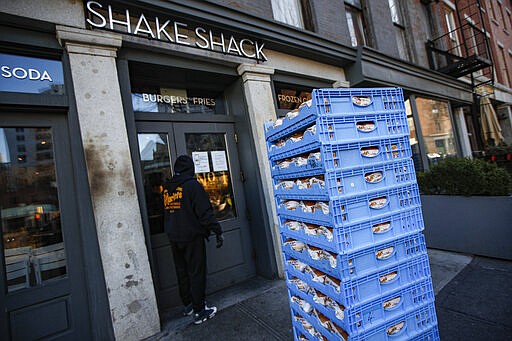 A bread delivery is made to a Shake Shack restaurant in the Brooklyn borough of New York, Monday, March 16, 2020.  Mayor Bill De Blasio is set to sign an executive order Monday shutting bars and restaurants. The order, which takes effect Tuesday, limits food service to takeout and delivery only.  (AP Photo/John Minchillo)