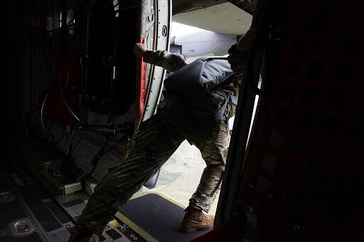 In this Jan. 26, 2020, photo, an American jumpmaster leans out of a C-130 in flight over Melgar, Colombia, to &quot;clear the rear,&quot; referring to the process paratroopers use to make sure all jumpers have exited their parachutes. (AP Photo/Sarah Blake Morgan)