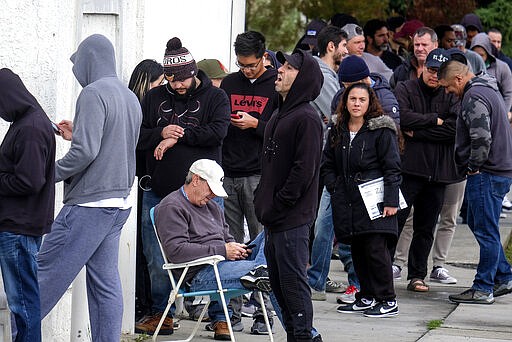 People wait in a line to enter a gun store in Culver City, Calif., Sunday, March 15, 2020. Coronavirus concerns have led to consumer panic buying of grocery staples, and now gun stores are seeing a similar run on weapons and ammunition as panic intensifies. (AP Photo/Ringo H.W. Chiu)