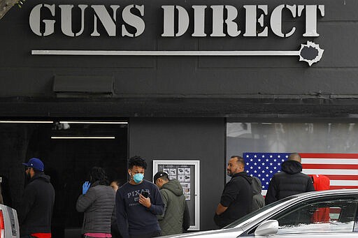 Gun store patrons wait in line, Sunday, March 15, 2020, in Burbank, Calif. Consumers are buying all kinds of goods in large quantities amid coronavirus concerns, putting pressure on inventories. Some people in line simply wanted to stock up on ammunition, while others said they were buying guns for protection in case their homes get invaded for food and other necessities. (AP Photo/Mark J. Terrill)