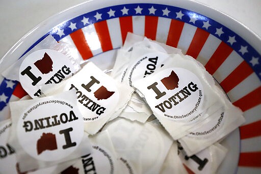 A bowl of stickers for those taking advantage of early voting, Sunday, March 15, 2020, in Steubenville, Ohio. Elections officials in the four states, Arizona, Florida, Illinois and Ohio, holding presidential primaries next week say they have no plans to postpone voting amid widespread disruptions caused by the coronavirus outbreak. Instead, they are taking extraordinary steps to ensure that voters can cast ballots and polling places are clean. (AP Photo/Gene J. Puskar)