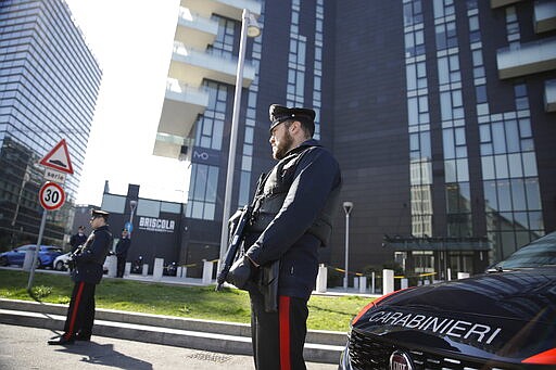 Italian Carabinieri police officers man a road block in Milan, Italy, Monday, March 16, 2020. Italy is on a nationwide lockdown to contain the COVID-19 virus outbreak. For most people, the new coronavirus causes only mild or moderate symptoms. For some it can cause more severe illness. (AP Photo/Luca Bruno)