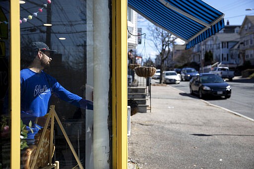 Darcy Coleman locks the door to Rebelle Artisan Bagels after handing an online order to a customer outside as the restaurant closed its doors to dine-in service Monday, March 16, 2020, in Providence, R.I. State officials on Monday ordered restaurants and bars to end dine-in service as the total number of cases of the new coronavirus in the state has risen to 21. The vast majority of people recover from the new virus. According to the World Health Organization, people with mild illness recover in about two weeks, while those with more severe illness may take three to six weeks to recover. (AP Photo/David Goldman)