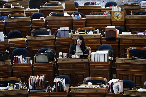 State Rep. Tracy Ehlert, D-Cedar Rapids, works at her desk in the Iowa House, Monday, March 16, 2020, at the Statehouse in Des Moines, Iowa. I Iowa leaders are suspending the current legislative session for at least 30 days in efforts to prevent the spread of COVID-19 coronavirus. (AP Photo/Charlie Neibergall)