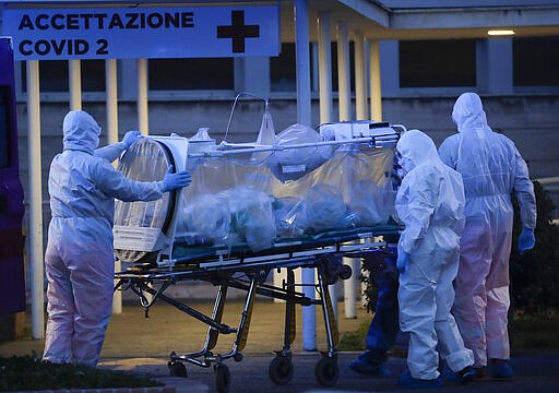 A patient in a biocontainment unit is carried on a stretcher at the Columbus Covid 2 Hospital in Rome, Monday, March 16, 2020. The new Columbus Covid 2 Hospital, an area fully dedicated to the COVID-19 cases at the Gemelli university polyclinic, opened today with 21 new ICU units and 32 new beds, in order to support the regional health authorities in trying to contain the pandemic. Sign at top in Italian reads &quot;Admission COVID 19&quot;. For most people, the new coronavirus causes only mild or moderate symptoms. For some it can cause more severe illness, especially in older adults and people with existing health problems. (AP Photo/Alessandra Tarantino)