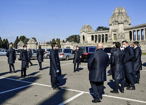 Pallbearers wait outside a cemetery in Bergamo, northern Italy, Monday, March 16, 2020. Bergamo is one of the cities most hit by the new coronavirus outbreak in northern Italy. For most people, the new coronavirus causes only mild or moderate symptoms. For some it can cause more severe illness.(Claudio Furlan/LaPresse via AP)