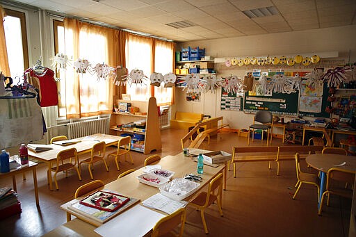 An empty classroom is seen at a closed school in Paris, Monday, March 16, 2020. France plans to close all creches, schools and universities from Monday until further notice to limit the spread of the novel coronavirus, President Emmanuel Macron says. For most people, the new coronavirus causes only mild or moderate symptoms. For some it can cause more severe illness, especially in older adults and people with existing health problems. (AP Photo/Thibault Camus)