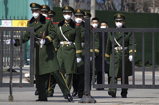 Paramilitary wearing masks assemble for work in an embassy district in Beijing on Monday, March 16, 2020. With more imported cases of the new coronavirus, starting Monday, travelers arriving in Beijing from overseas will be quarantined for 14 days in designated facilities at their own expense. (AP Photo/Ng Han Guan)