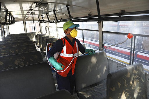 A worker disinfects a police bus as a precaution against COVID-19 in New Delhi, India, Monday, March 16, 2020. The vast majority of people recover from the new virus. According to the World Health Organization, people with mild illness recover in about two weeks, while those with more severe illness may take three to six weeks to recover. (AP Photo/Manish Swarup)