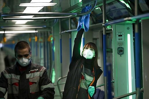 Moscow metro depot employees disinfect a metro train in Moscow, Russia, Monday, March 16, 2020. Starting from early March, Moscow authorities have been sending people who traveled to countries most affected by the coronavirus epidemic and returned with flu-like symptoms to a new hospital on the outskirts of the city. For most people, the new coronavirus causes only mild or moderate symptoms, such as fever and cough. For some, especially older adults and people with existing health problems, it can cause more severe illness, including pneumonia. (AP Photo/Pavel Golovkin)