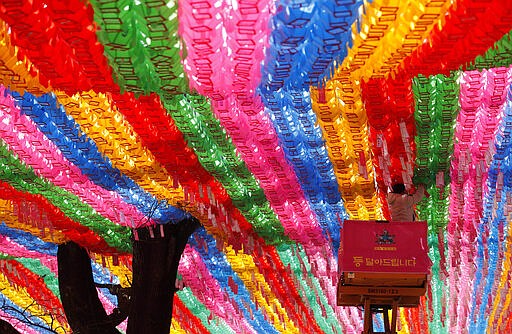 A man wearing a face mask worn during the coronavirus outbreak attaches the name tag of a Buddhist in preparation for the upcoming birthday of Buddha on April 30 at the Jogye temple in Seoul, South Korea, Monday, March 16, 2020. For most people, the new coronavirus causes only mild or moderate symptoms, such as fever and cough. For some, especially older adults and people with existing health problems, it can cause more severe illness, including pneumonia. (AP Photo/Lee Jin-man)