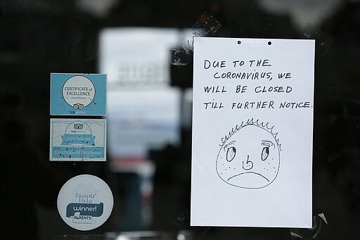 A closed sign is posted to the entrance of the Mus&eacute;e M&eacute;canique penny arcade at Fisherman's Wharf Monday, March 16, 2020, in San Francisco. Officials in six San Francisco Bay Area counties issued a shelter-in-place mandate Monday affecting nearly 7 million people, including the city of San Francisco itself. The order says residents must stay inside and venture out only for necessities for three weeks starting Tuesday in a desperate attempt by officials to curb the spread of the novel coronavirus. (AP Photo/Eric Risberg)