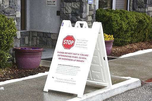 Signs such as this, seen Monday, March 16, 2020 are becoming more common at many of Nevada County's facilities that house senior populations, warning those that may have symptoms of coronavirus or COVID-19, to stay away from this facility.  (Elias Funez/The Union via AP)