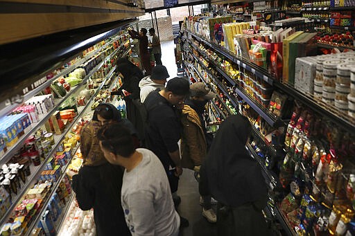 People shop at a grocery in Bamland shopping mall, in Western Tehran, Iran, Sunday, March 15, 2020. Many people in Tehran shrugged off warnings over the new coronavirus as authorities complained that most people in the capital are not treating the crisis seriously enough. (AP Photo/Vahid Salemi)