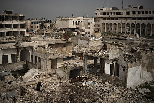 In this Thursday, March 12, 2020 photo, a woman stands atop a building in a neighborhood heavily damaged by airstrikes in Idlib, Syria. Idlib city is the last urban area still under opposition control in Syria, located in a shrinking rebel enclave in the northwestern province of the same name. Syria&#146;s civil war, which entered its 10th year Monday, March 15, 2020, has shrunk in geographical scope -- focusing on this corner of the country -- but the misery wreaked by the conflict has not diminished. (AP Photo/Felipe Dana)