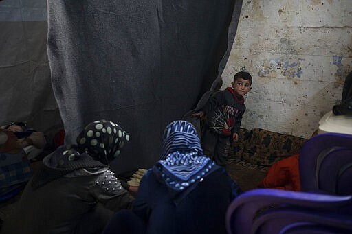 In this Thursday, March 12, 2020 photo, women prepare food in a room inside Idlib's old central prison, now transformed into a camp for people displaced by fighting, in Idlib, Syria. Idlib city is the last urban area still under opposition control in Syria, located in a shrinking rebel enclave in the northwestern province of the same name. Syria&#146;s civil war, which entered its 10th year Monday, March 15, 2020, has shrunk in geographical scope -- focusing on this corner of the country -- but the misery wreaked by the conflict has not diminished. (AP Photo/Felipe Dana)