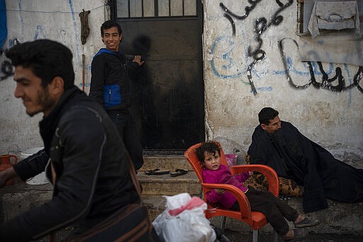 In this Thursday, March 12, 2020 photo, Syrians gather inside Idlib's old central prison, now transformed into a camp for people displaced by fighting, in Idlib, Syria. Idlib city is the last urban area still under opposition control in Syria, located in a shrinking rebel enclave in the northwestern province of the same name. Syria&#146;s civil war, which entered its 10th year Monday, March 15, 2020, has shrunk in geographical scope -- focusing on this corner of the country -- but the misery wreaked by the conflict has not diminished. (AP Photo/Felipe Dana)