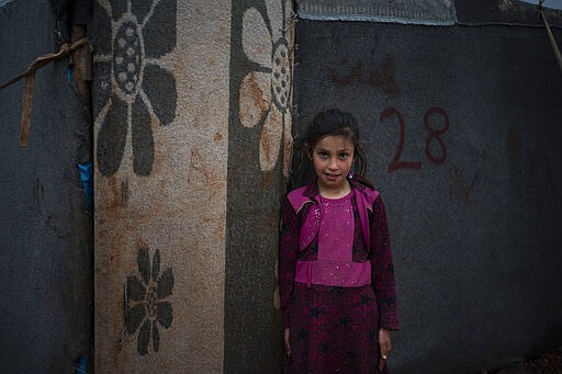 In this Thursday, March 12, 2020 photo, Yasmin poses for photo outside her tent at an informal camp for people displaced by fighting outside of Idlib city, Syria. Idlib city is the last urban area still under opposition control in Syria, located in a shrinking rebel enclave in the northwestern province of the same name. Syria&#146;s civil war, which entered its 10th year Monday, March 15, 2020, has shrunk in geographical scope -- focusing on this corner of the country -- but the misery wreaked by the conflict has not diminished. (AP Photo/Felipe Dana)