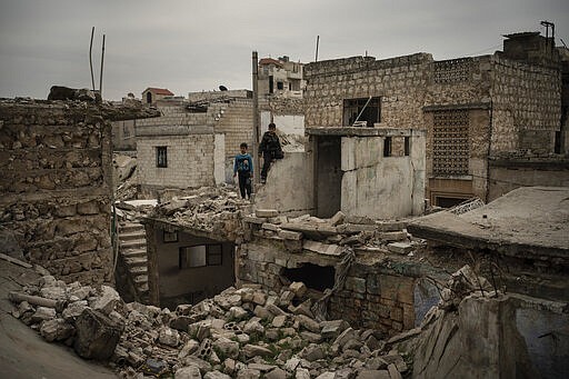 In this Thursday, March 12, 2020 photo, children play on the rubble of houses destroyed by airstrikes, in Idlib, Syria. Idlib city is the last urban area still under opposition control in Syria, located in a shrinking rebel enclave in the northwestern province of the same name. Syria&#146;s civil war, which entered its 10th year Monday, March 15, 2020, has shrunk in geographical scope -- focusing on this corner of the country -- but the misery wreaked by the conflict has not diminished. (AP Photo/Felipe Dana)