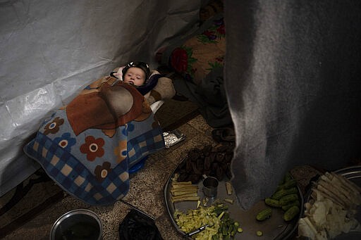 In this Thursday, March 12, 2020 photo, a baby sleeps in a room inside Idlib's old central prison, now transformed into a camp for people displaced by fighting, in Idlib, Syria. Idlib city is the last urban area still under opposition control in Syria, located in a shrinking rebel enclave in the northwestern province of the same name. Syria&#146;s civil war, which entered its 10th year Monday, March 15, 2020, has shrunk in geographical scope -- focusing on this corner of the country -- but the misery wreaked by the conflict has not diminished. (AP Photo/Felipe Dana)