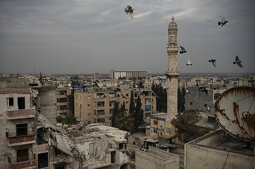 In this Thursday, March 12, 2020 photo, a mosque stands next to a a damaged building, in Idlib, Syria. Idlib city is the last urban area still under opposition control in Syria, located in a shrinking rebel enclave in the northwestern province of the same name. Syria&#146;s civil war, which entered its 10th year Monday, March 15, 2020, has shrunk in geographical scope -- focusing on this corner of the country -- but the misery wreaked by the conflict has not diminished. (AP Photo/Felipe Dana)