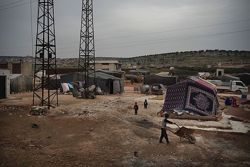 In this Thursday, March 12, 2020 photo, children play in an informal camp for people displaced by fighting outside of Idlib city, Syria. Idlib city is the last urban area still under opposition control in Syria, located in a shrinking rebel enclave in the northwestern province of the same name. Syria&#146;s civil war, which entered its 10th year Monday, March 15, 2020, has shrunk in geographical scope -- focusing on this corner of the country -- but the misery wreaked by the conflict has not diminished. (AP Photo/Felipe Dana)