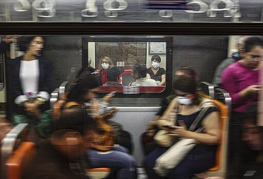 Commuters wear face masks as a precaution against the COVID-19 illness in the subway in Santiago Chile, Monday, March 16, 2020. For most people, the new coronavirus causes only mild or moderate symptoms. For some, it can cause more severe illness, especially in older adults and people with existing health problems. (AP Photo/Esteban Felix)