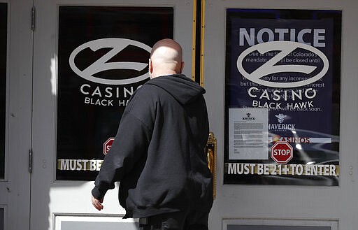 A man reads the sign on the front door of a shuttered casino after all casinos have been closed to the public in the state's efforts to fend off the spread of coronavirus Tuesday, March 17, 2020, in Black Hawk, Colo. According to the World Health Organization, most people recover in about two to six weeks depending on the severity of the illness. (AP Photo/David Zalubowski)