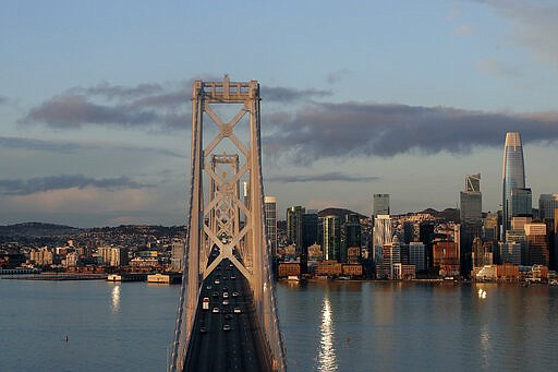 Cars drive west on the San Francisco-Oakland Bay Bridge in San Francisco, Tuesday, March 17, 2020. Officials in seven San Francisco Bay Area counties have issued a shelter-in-place mandate affecting about 7 million people, including the city of San Francisco itself. The order says residents must stay inside and venture out only for necessities for three weeks starting Tuesday. (AP Photo/Jeff Chiu)